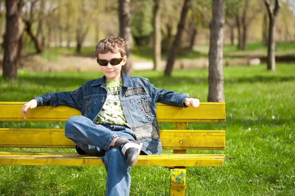 Cool kid sitting on bench — Stock Photo, Image