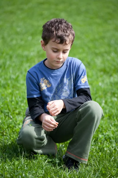 Πανέμορφο αγόρι σε ένα πεδίο χλόης — Φωτογραφία Αρχείου