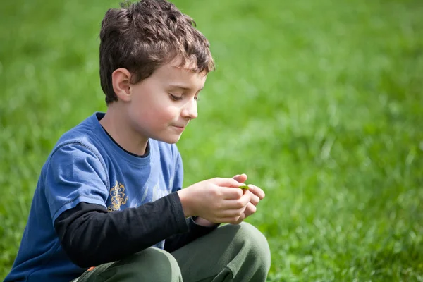 Nádherný chlapec v travnaté hřiště — Stock fotografie