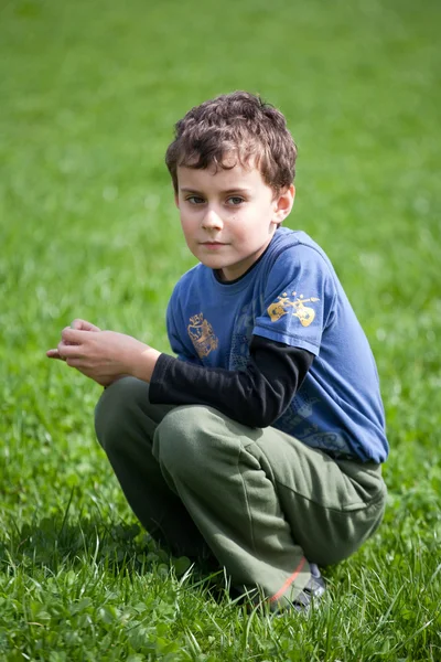 Hermoso niño en un campo de hierba — Foto de Stock