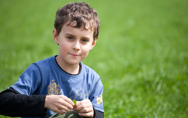 Wunderschöner Junge auf einem Rasenfeld — Stockfoto