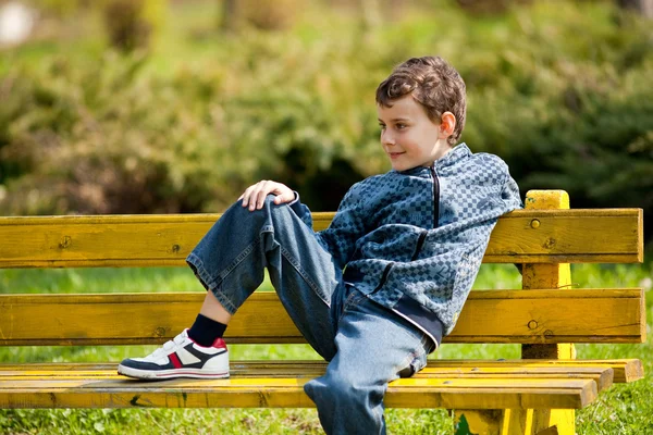 Cute schoolboy in a park — Stock Photo, Image