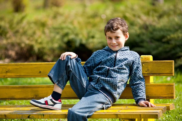 Cute schoolboy in a park — Stock Photo, Image