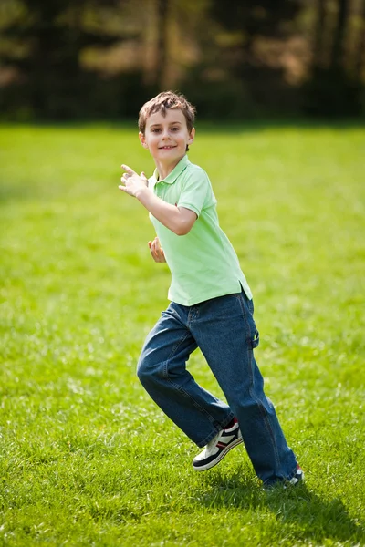 Junge rennt auf eine Wiese — Stockfoto