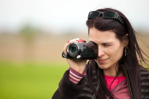 Young lady using video camera outdoors — Stock Photo, Image