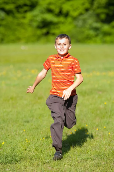 Miúdo bonito correndo na grama — Fotografia de Stock