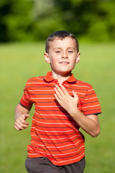 Roztomilé dítě běží na trávě — Stock fotografie