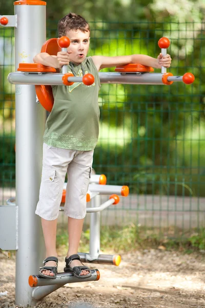 Мальчик делает фитнес на открытом воздухе и весело — стоковое фото