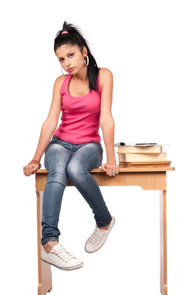 Симпатичная девушка-подросток сидит на столе — стоковое фото