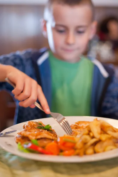 Mały chłopiec, jedzenie w restauracji — Zdjęcie stockowe