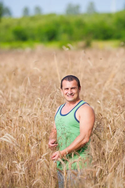 Jovem agricultor no seu campo de trigo — Fotografia de Stock