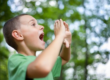 Little boy shouting in the forest clipart