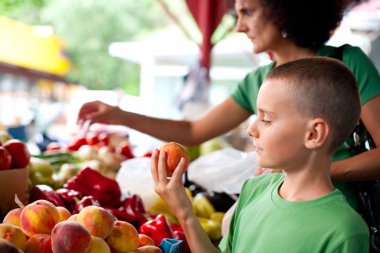 Cute boy buying vegetables clipart