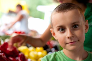 Cute boy buying vegetables clipart