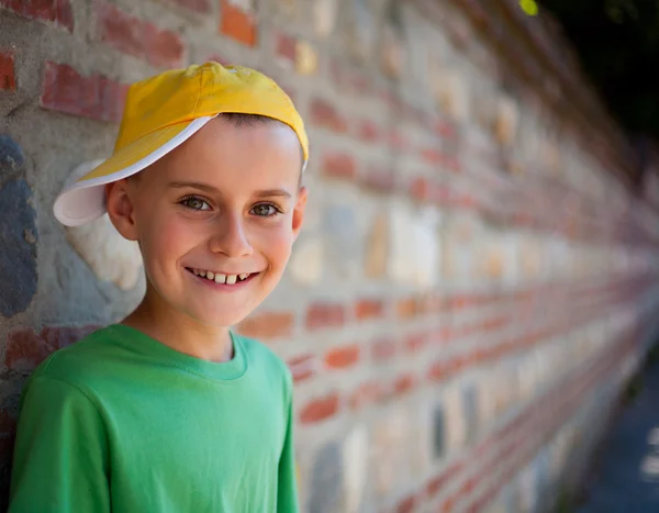Cute child leaning on a wall — Stock Photo, Image