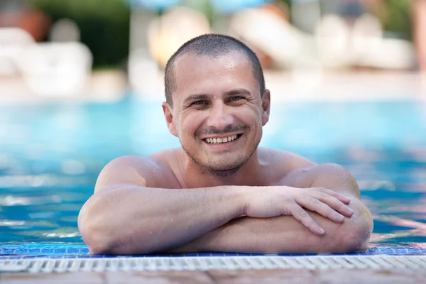 Счастливый молодой человек в бассейне — стоковое фото