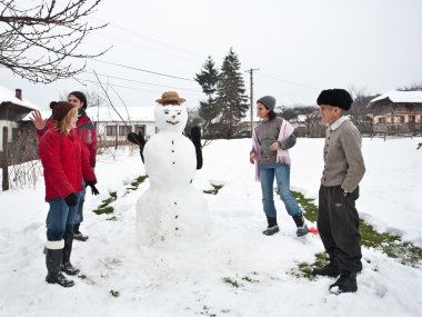 Happy family around a snowman clipart