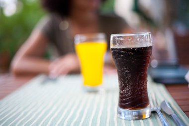 Glass with coke and lady in background clipart