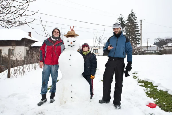 Три мальчика и снеговик — стоковое фото