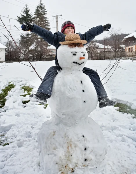 Χαριτωμένο παιδί και χιονάνθρωπος — Φωτογραφία Αρχείου