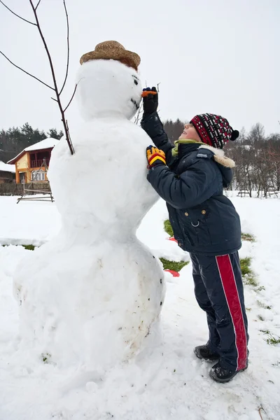 Bonito garoto e boneco de neve — Fotografia de Stock