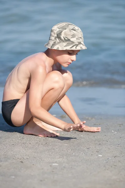 Little boy with hat playing on the beach — Stock Photo, Image