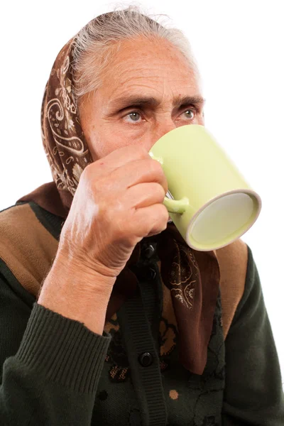 Femme âgée buvant dans une tasse — Photo