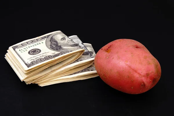 Dolarů a brambor izolovaných na černém — Stock fotografie