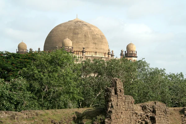 stock image Gol Gumbaz behind foliage