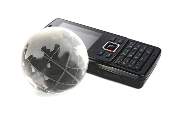 Стеклянный глобус и мобильный телефон — стоковое фото