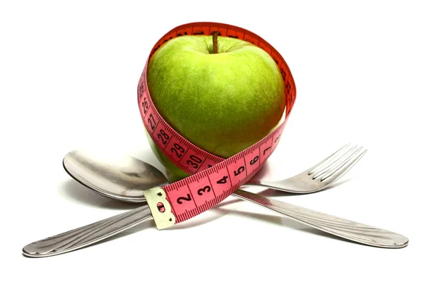 Spoon fork and apple is strung by a ribbon for measuring diet — Stock Photo, Image