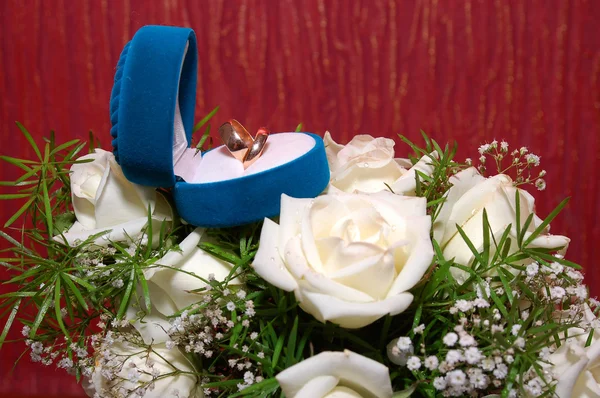 在蓝色框和玫瑰结婚戒指 — 图库照片