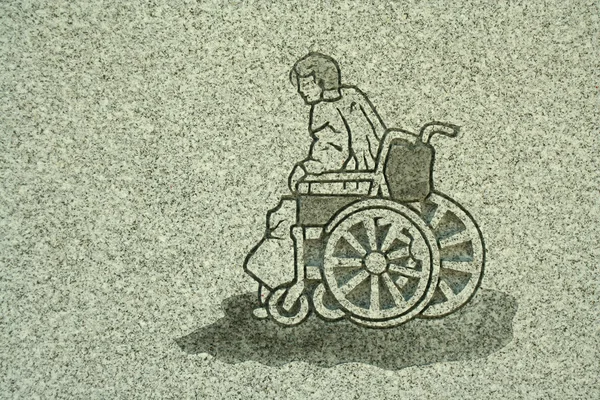Escultura em pedra de um homem em uma cadeira de rodas — Fotografia de Stock