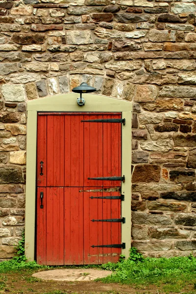 Kırmızı kapının üzerinde eski bir taş bina — Stok fotoğraf