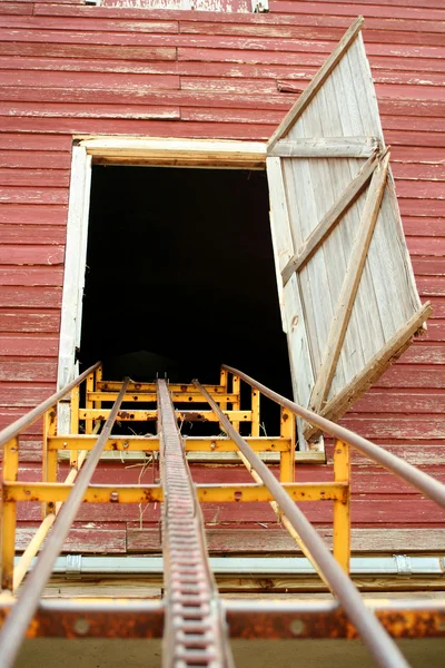 Hay conveyor leading up to a barn door — Stock Photo, Image