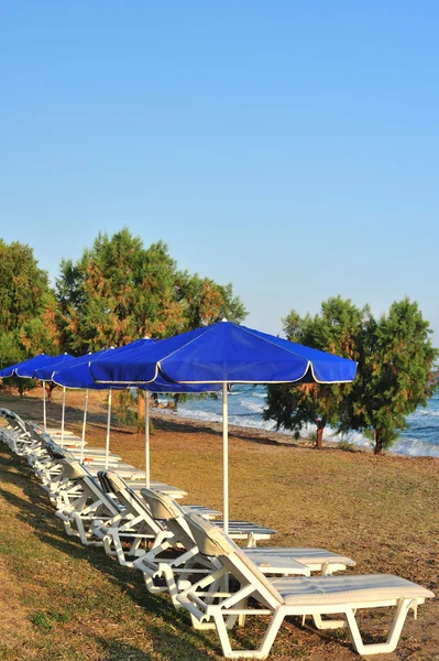 Playa con sombrillas azules — Foto de Stock