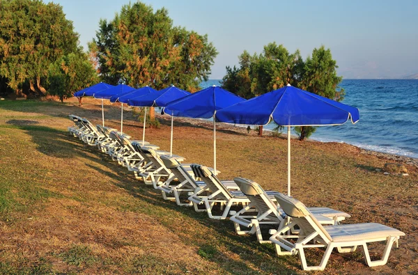 Пляж с голубыми зонтиками — стоковое фото