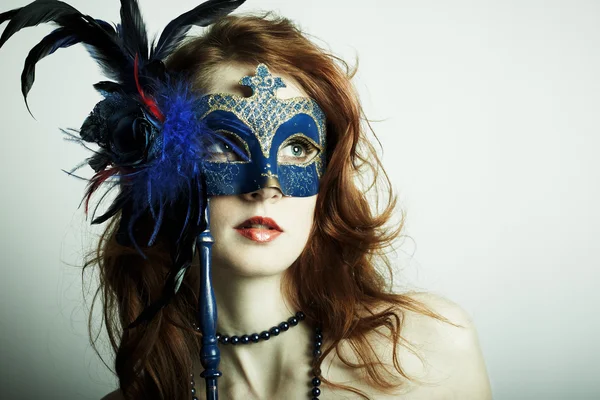 Het mooie jonge meisje in een masker — Stockfoto