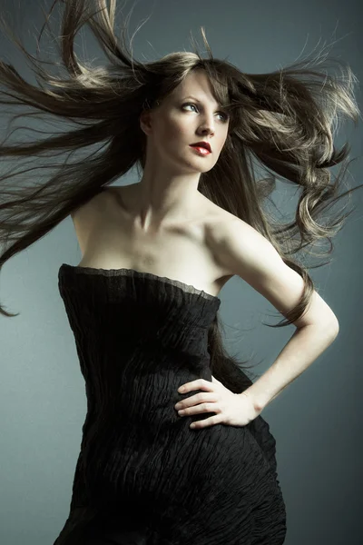 Den unga vackra flickan i svart klänning — Stockfoto
