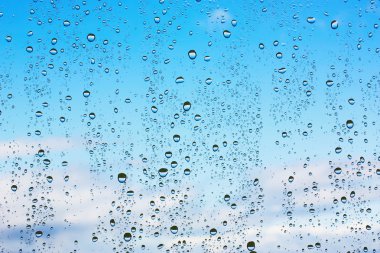 Water droplets on glass against the blue sky clipart