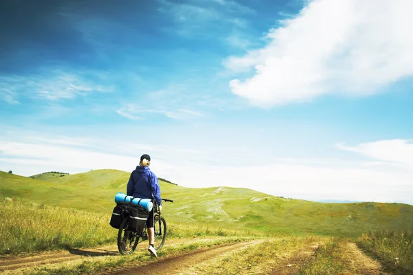 Жінка їде на велосипеді проти гір — стокове фото