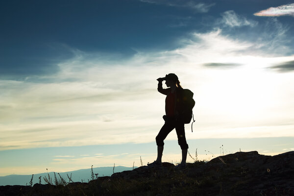 Silhouette of the girl looking in a distance against a decline