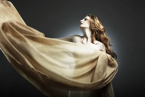 Portret van de jonge vrouw tegen een vliegende stof — Stockfoto