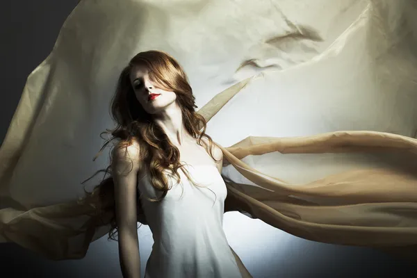 Retrato de la joven mujer contra una tela voladora — Foto de Stock