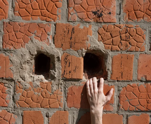 Mão em uma parede de tijolo — Fotografia de Stock