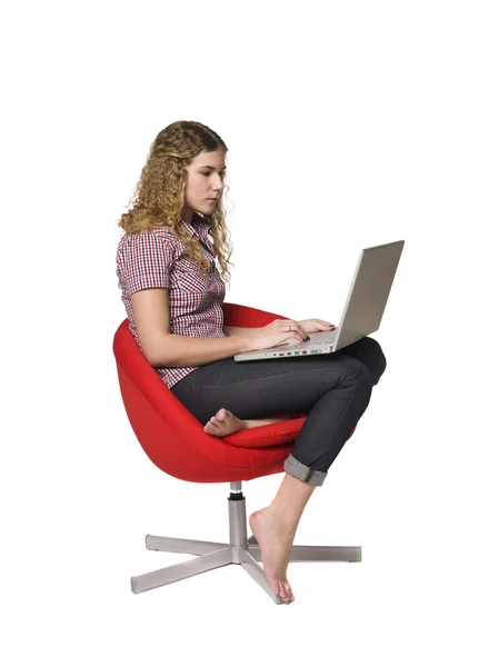 Κορίτσι σε μια πολυθρόνα με έναν υπολογιστή — Φωτογραφία Αρχείου