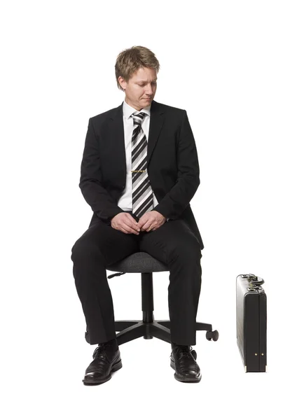 Бизнесмен сидит на офисном стуле — стоковое фото