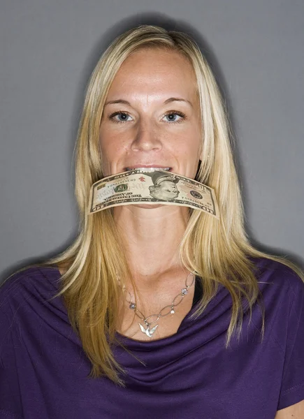 Mujer con un billete de dólar en la boca — Foto de Stock