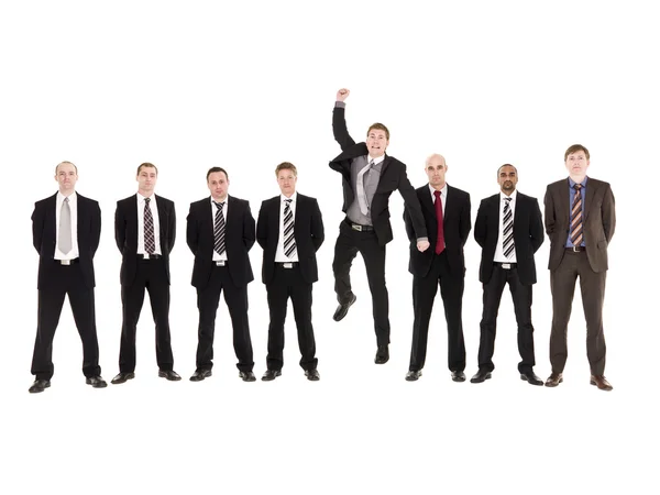 Jumping man in a row with other men — Stock Photo, Image