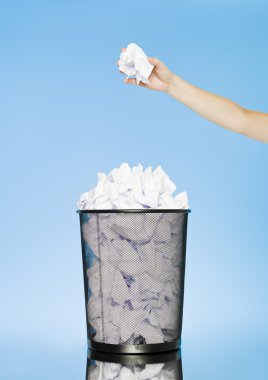 Trowing a paper to a wastebasket clipart